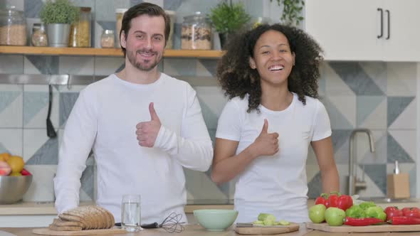 Mixed Race Couple Showing Thumbs Up Sign in Kitchen