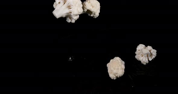 Cauliflower, brassica oleracea, Vegetable falling into Water against Black Background