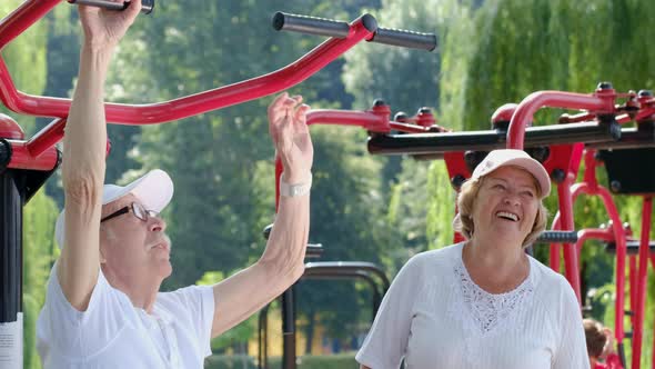 Happy retired couple playing sports outdoors on a beautiful sunny summer day.