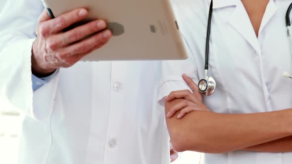 Happy doctors looking at tablet computer