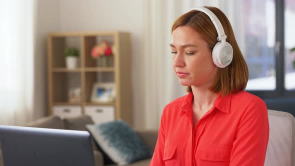 Woman in Headphones with Laptop Working at Home