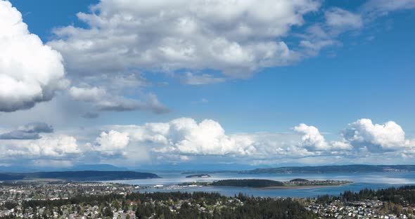 Wide panning aerial shot of the cloudy and blue sky above Whidbey Island's Oak Harbor.
