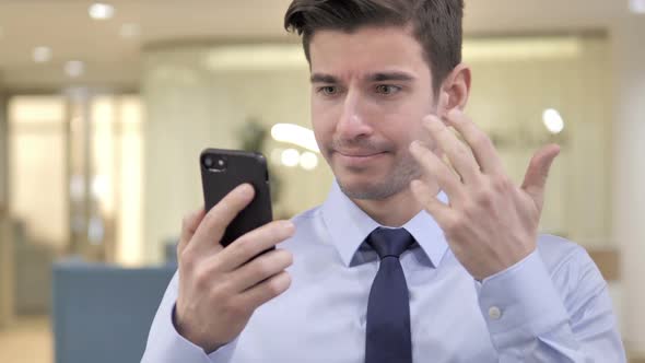Businessman Reacting to Loss on Smartphone