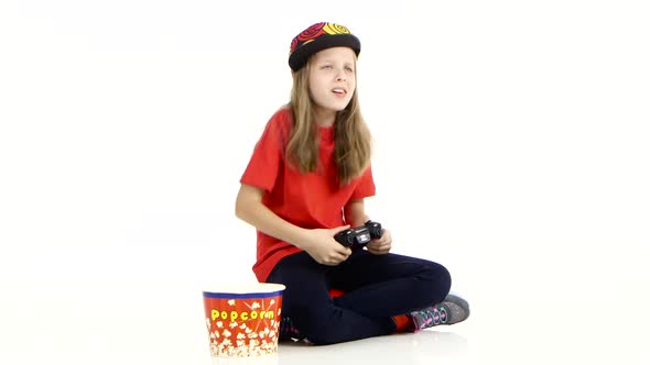 Teen Eats Popcorn and Plays with Joystick in Online Game