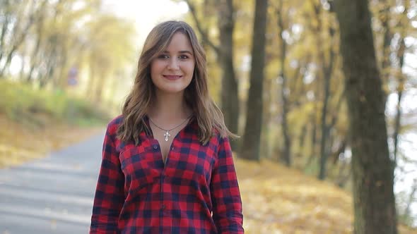 Beautiful brunette girl walks in the autumn park