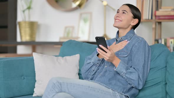 Latin Woman Cheering on Smartphone at Work, Success 