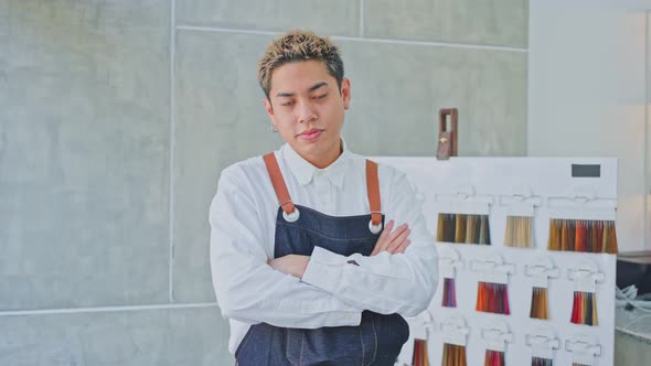 Asian hairstylist or Hairdresser man standing confidence with arm crossed looking at camera in salon