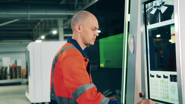 Professional Male Worker Using a Screen to Operate a Complex Machine