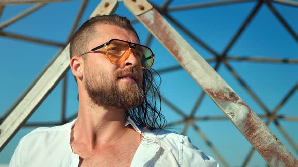 Closeup Confident Face of Bearded Fashion Male Wearing Sunglasses Posing at Grid Background