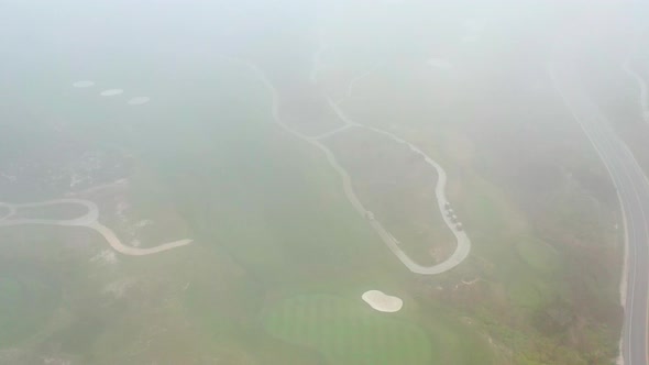 Cinematic aerial view of golf course revealed through fog. Monterey Pacific Golf Course