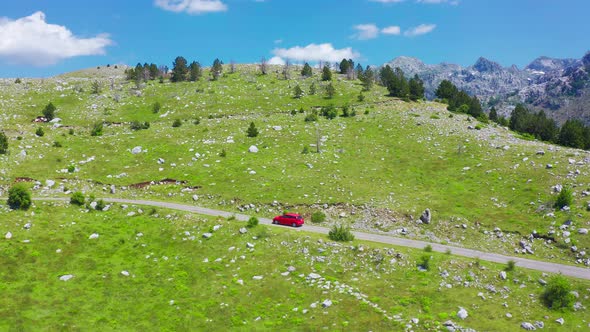 Aerial View of Road with Red Car in Beautiful Mountains in Komovi Montenegro