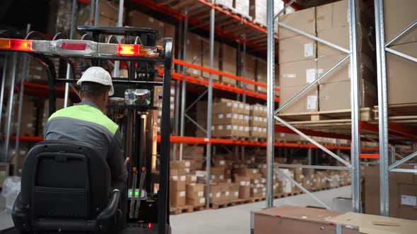 Warehouse Worker Moving Goods Riding Forklift