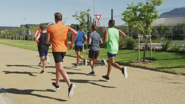 Men running outside on sunny day