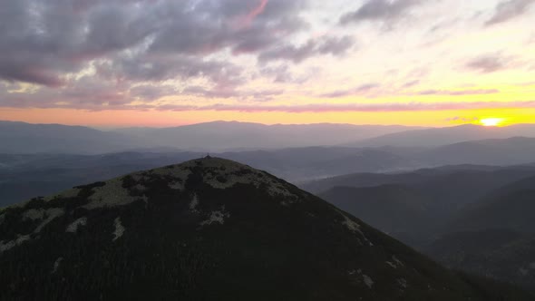 Aerial View of Bright Foggy Morning Over Dark Peak with Mountain Forest Trees at Autumn Sunrise