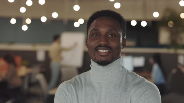 Happy Young African American Handsome Businessman Looking at the Camera Standing in Modern Office