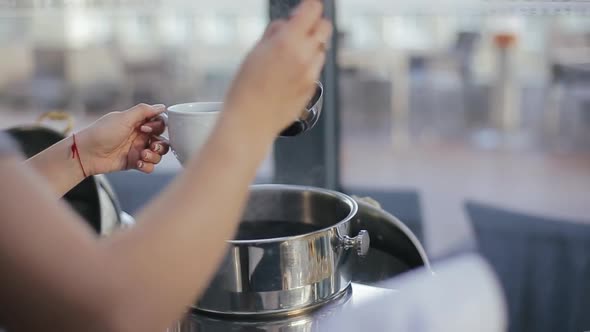 Waitress Pours Mulled Wine Into Cup for Guests of a Wedding Party in the Morning at the Banquet Hall