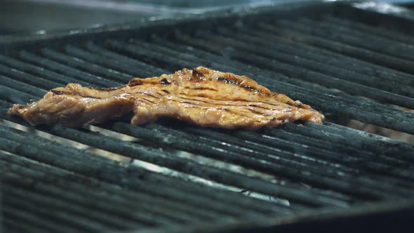 Medium Shot of Meat on Grill Turned