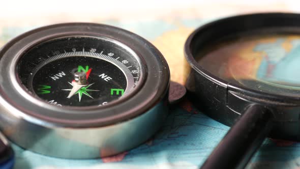 Close Up of a Compus with Travel Map on Table