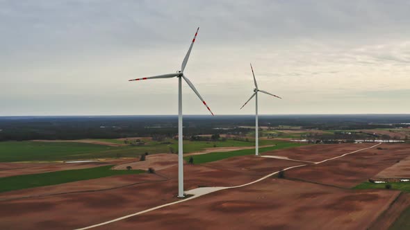 Wind turbines on brown field in cloudy day, aerial view