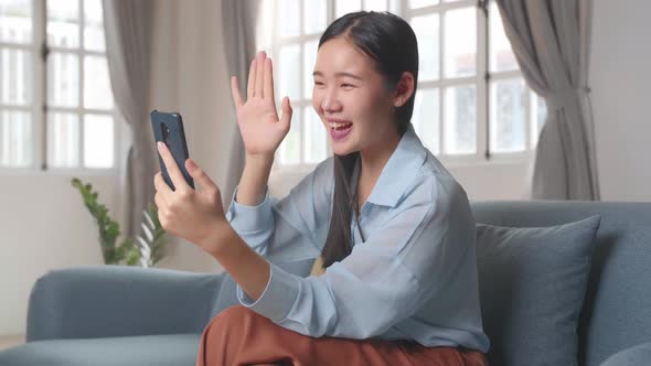 Female Make A Smartphone Video Call In Living Room