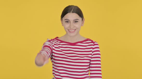 Spanish Woman Pointing at the Camera on Yellow Background