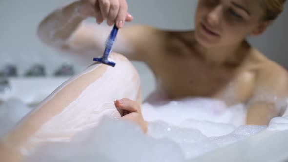Young Female Shaving Legs in Bath, Daily Beauty Procedure, Soft Moisturized Skin