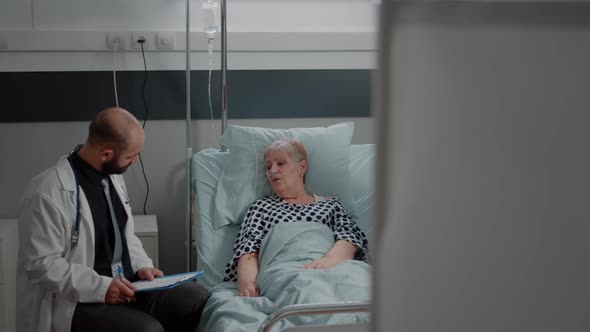 Doctor and Nurse Doing Consultation with Retired Patient