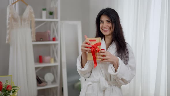 Medium Shot Portrait of Slim Excited Young Bride Looking in Gift Box Smiling Looking at Camera