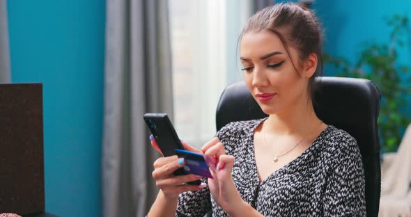 Gorgeous Young Girl Sititng at Home Using Mobile Banking Application on Her Gadget While Paying