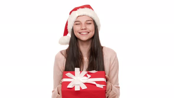 Portrait of Young Woman with Festive Emotions Wearing Santa Claus Red Hat Being Happy Giving Amazing