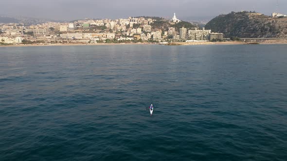 Aerial view of a man paddling kayak mediterranean sea.