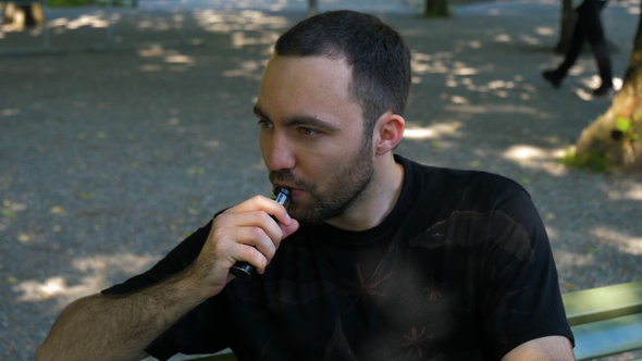 Man smoking the vape outdoors.