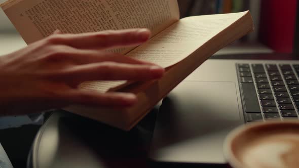 Woman Reading a Book Sitting in a Cafe