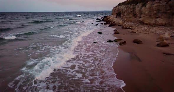 beautiful waves on the beach banging on the rocks at sunset