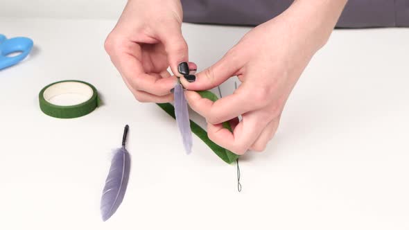 Girl Makes Jewelry Out of Feathers. Close Up