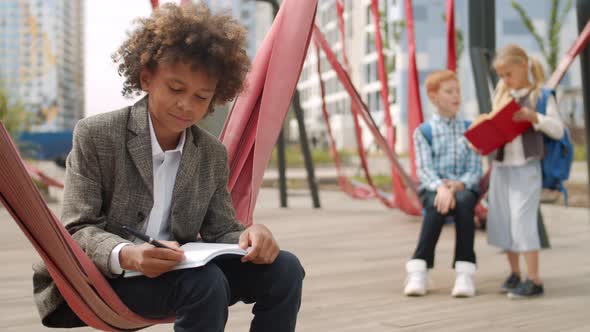 Schoolboy Doing Homework Outdoors