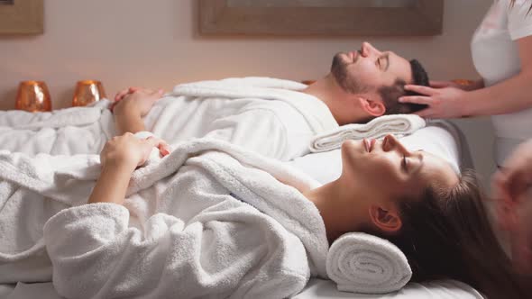 Couple Enjoying a Face Massage in Spa Center.