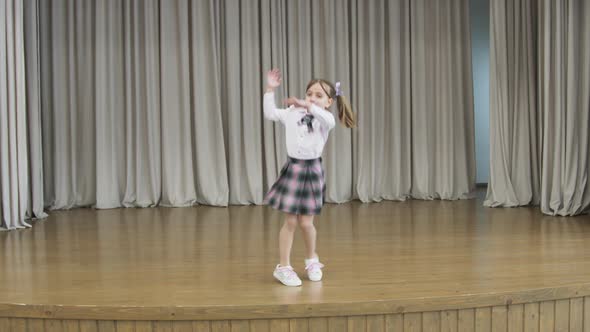 Little Girl on Stage in a Hall Without People. the Girl Revolves Around Herself.