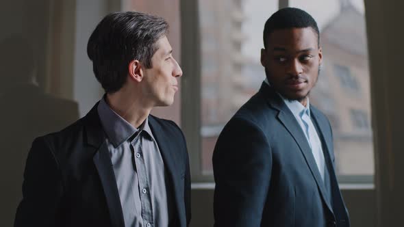 Two Coworker Colleagues Stand in Modern Company Office Look Out Window Happy Caucasian Business Man