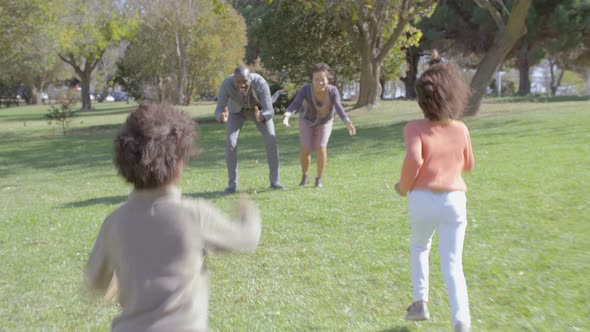 Happy Daughter and Son Running To Parents in Sunny Park in Slow Motion