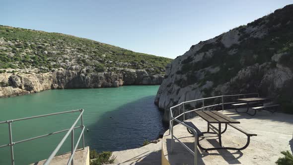 Empty Tables with Seats on Magrr Ix-Xini Bay on Sunny Day in Gozo Island