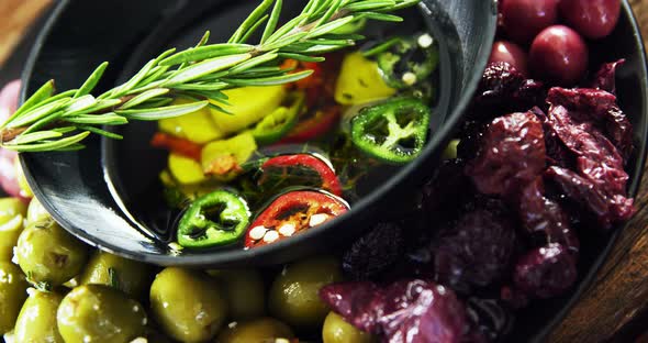 Olives, rosemary and chopped pepper in olive oil