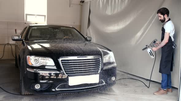 Man Washing His Car in a Garage