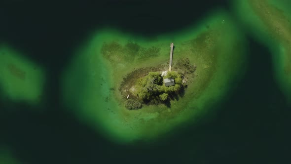 Isolated island Maximiliansinsel in German lake Eibsee, aerial drone view