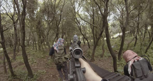 POV footage of armed terrorists patrolling a forest area