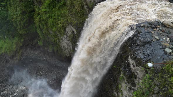 Aerial top down showing gigantic waterfall crashing down the cliff in jungle of Ecuador - Slow motio