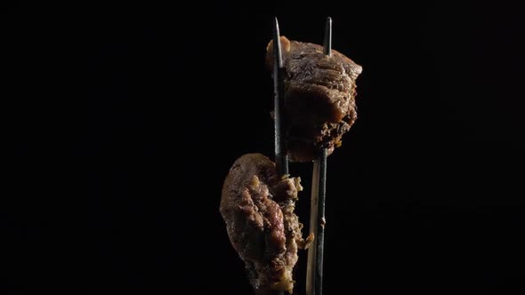 Fork with Pieces of Delicious Barbecued Meat on Black Background