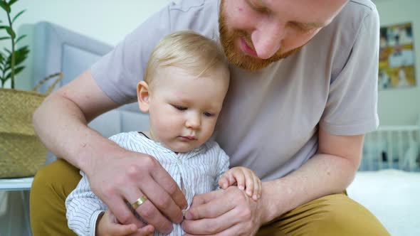 Young father taking care of cute toddler at home