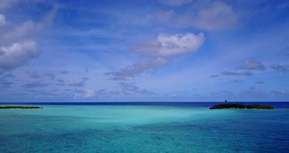 Wide angle flying abstract shot of a paradise sunny white sand beach and aqua blue water background 