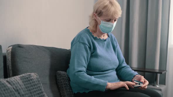 Elderly Woman Measures Oxygen Saturation